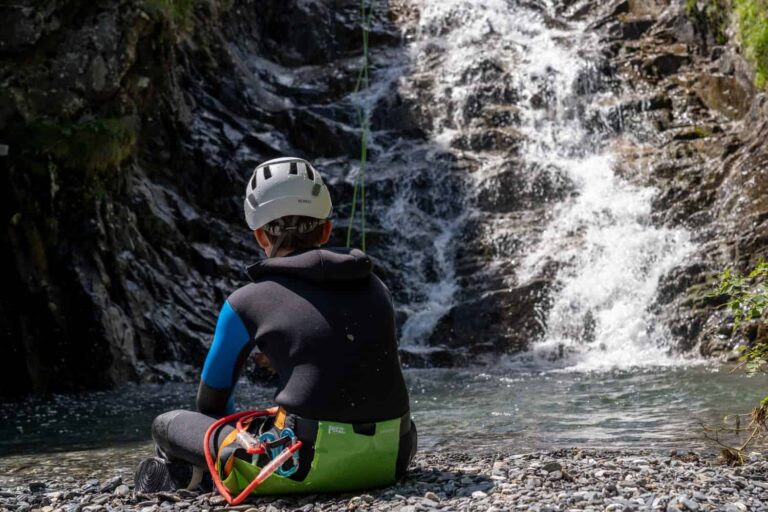 Pause au bord d'une vasque, face à une cascade, canyoning en Guadeloupe