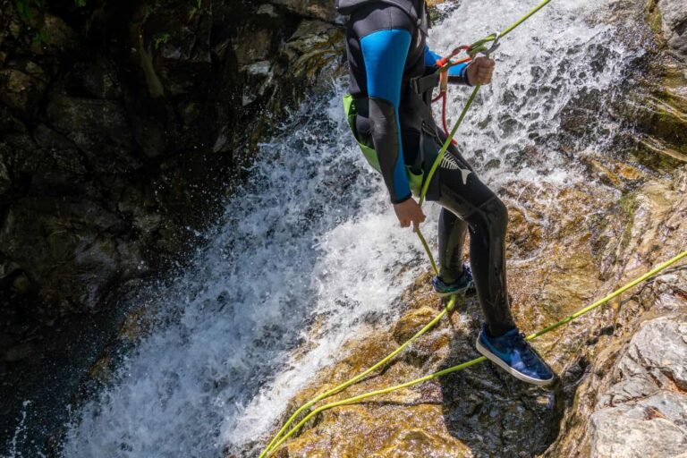 Canyoniste en rappel dans le flot d'une cascade, canyoning en Guadeloupe
