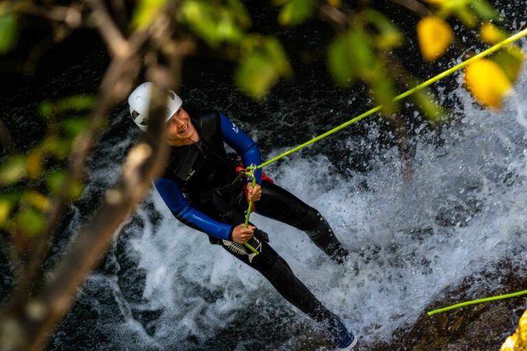 Canyoniste en rappel au cœur d'une cascade, sous la végétation tropicale, Guadeloupe
