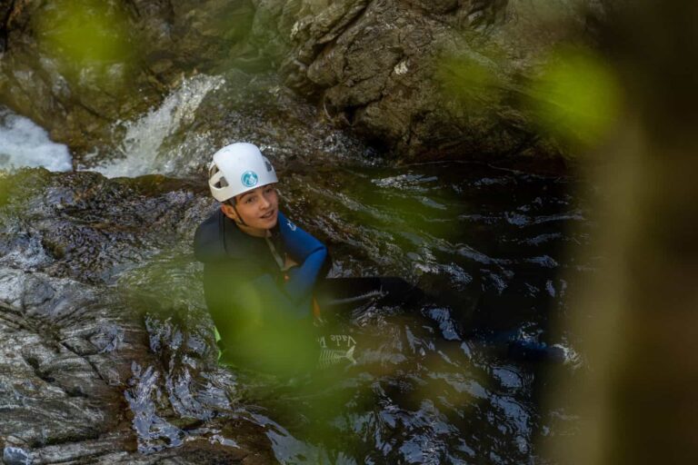 Canyoniste progressant entre rochers et eau vive, canyoning en Guadeloupe