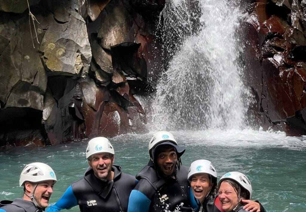 participants dans une vasque, avec combinaison et casque, pendant une sortie de canyoning en Guadeloupe