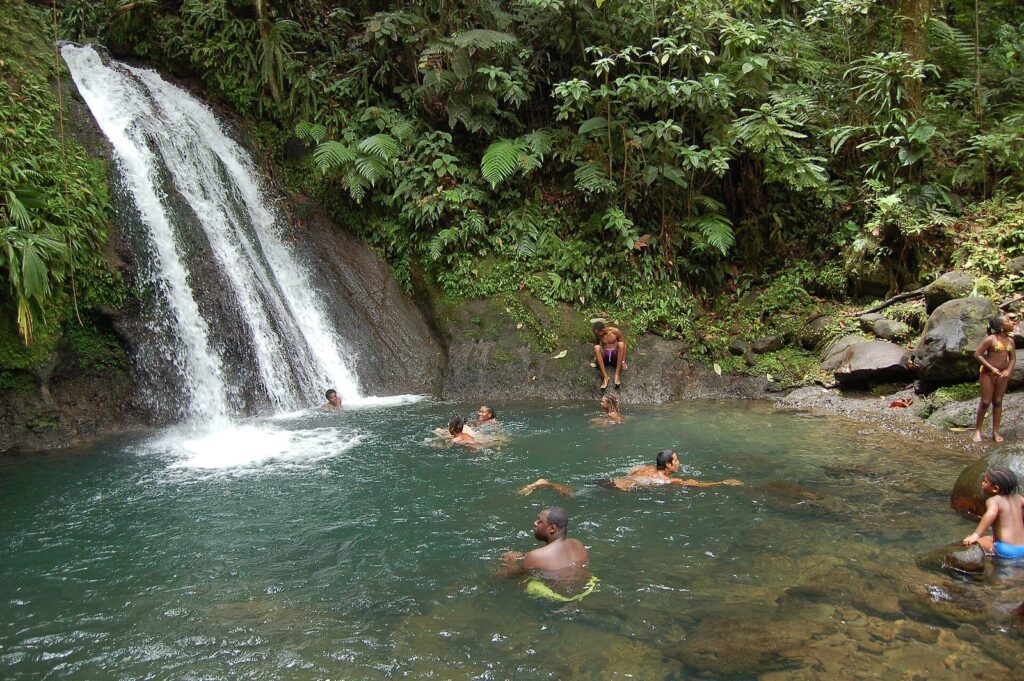 La cascade aux Écrevisses, en Basse-Terre : chute d’eau dans la forêt tropicale et baigneurs dans le bassin